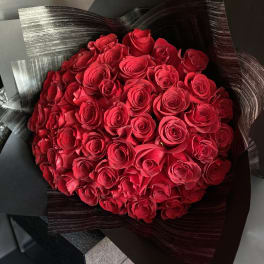 Bouquet of red roses wrapped in black paper