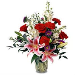 Mixed bouquet of red roses and pink lilies in a glass vase
