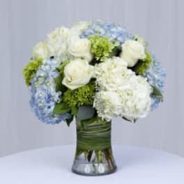 White and blue floral arrangement in a glass vase