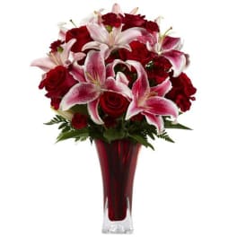 Red roses and pink lilies arranged in a tall red vase