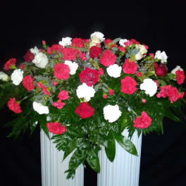 Large red, white, and pink floral arrangement in a white container
