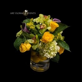 Yellow roses and orchids in a glass vase