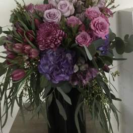 Pink and purple mixed bouquet in a black vase