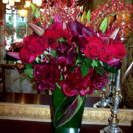 Tall red floral arrangement in a green vase
