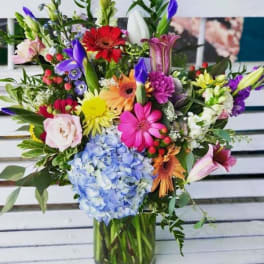 Colorful mixed bouquet in a glass vase with hydrangea and gerbera daisies