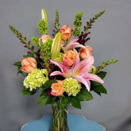 Pink lilies and peach roses in a glass vase