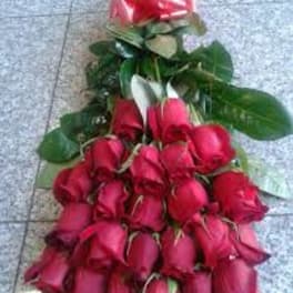 Cascade of red roses with a pink ribbon bow