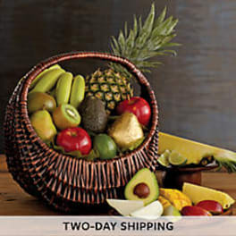 Basket of assorted fruit with a pineapple and avocados