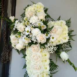 White floral cross arrangement with roses and daisies