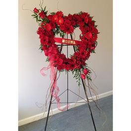 Heart-shaped red floral standing spray on an easel