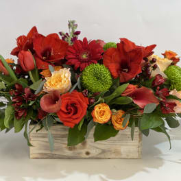 Mixed red and orange flowers in a wooden box arrangement