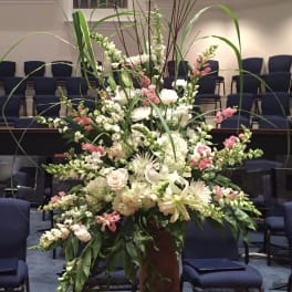 Large white and pink floral arrangement in a tall vase