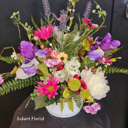 Colorful mixed bouquet in a white vase with purple, pink, and white blooms