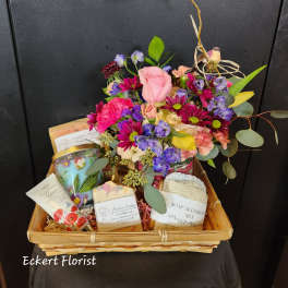 Gift basket with a mixed flower arrangement and bath products
