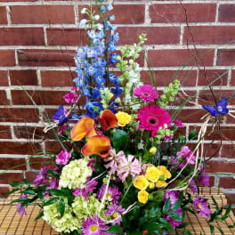Colorful mixed flower arrangement with calla lilies, roses, and daisies