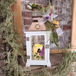 Decorative memorial lantern with a candle, ribbon, and butterfly accents