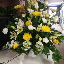 Large white and yellow floral arrangement in a vase