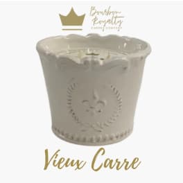 White decorative candle in a scalloped ceramic container