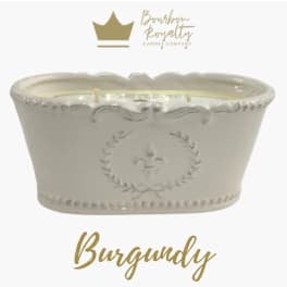 White ceramic candle vessel with gold logo and text