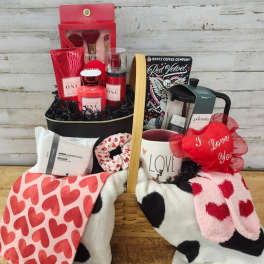 Gift basket with heart-patterned blankets, mug, candles, and beauty items