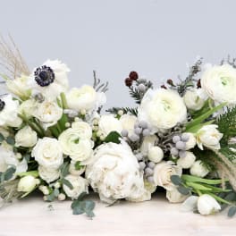 Low white floral arrangement with ranunculus and anemones