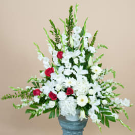 White floral arrangement with red roses in a blue vase