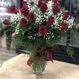 Red roses and white baby's breath in a clear glass vase