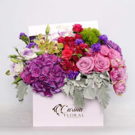Colorful bouquet in a white gift box with pink, purple, and red flowers