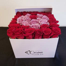 Box of red and pink roses arranged in a white gift box