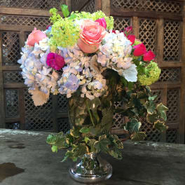 Mixed bouquet of roses and hydrangeas in a silver vase