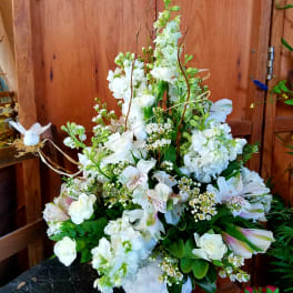 White mixed flower arrangement in a white basket