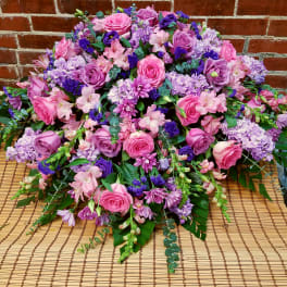 Large pink and purple floral arrangement with roses and mixed blooms