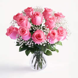 Pink roses arranged in a clear glass vase with baby's breath