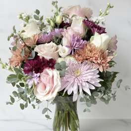 Pastel mixed flower bouquet in a clear glass vase