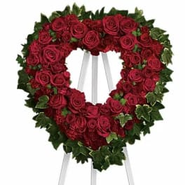 Heart-shaped wreath of red roses on a stand