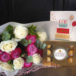 Bouquet of white and pink roses with a birthday card and Ferrero Rocher chocolates