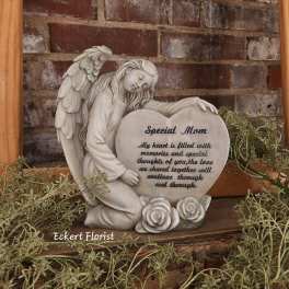 Angel figurine holding a heart-shaped memorial plaque with roses