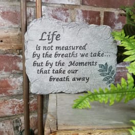 Stone plaque with a quote against a brick wall