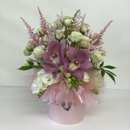 Pink orchid and white rose arrangement in a pastel hatbox