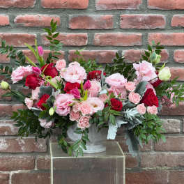 Pink and red floral arrangement in a white vase
