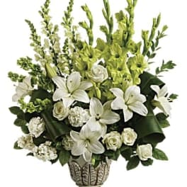 White lilies and roses in a decorative vase with green flowers