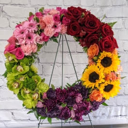 Colorful floral wreath on a metal stand with roses and sunflowers