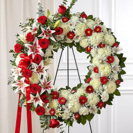 Large floral wreath with red roses and white blooms on a stand