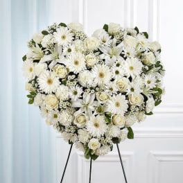 Heart-shaped white floral arrangement on a stand