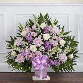 Lavender and white floral standing spray with a purple ribbon bow