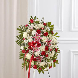 Standing floral spray with red and white flowers on an easel