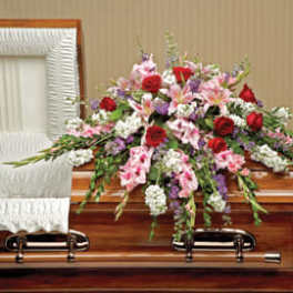 Casket spray with red, pink, white, and purple flowers