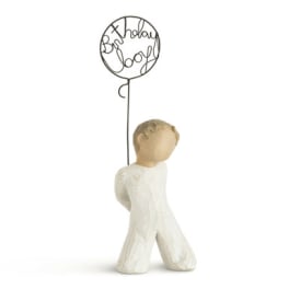 Small angel figurine holding a wire balloon that says "Birthday Boy"