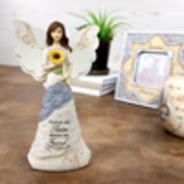 Angel figurine holding a sunflower with wings and a memorial-style dress