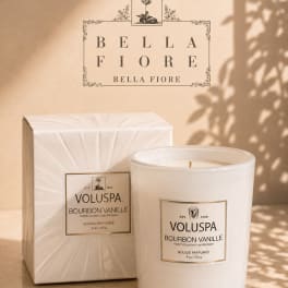 White scented candle with matching box on a beige surface